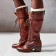Brown leather knee-high boots with white fur lining on a neutral background