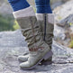 Green knee-high boots with zippers and knit cuffs worn outdoors on a rocky surface.