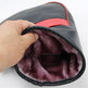 Hand holding a gray and red bag with purple interior lining on a white background