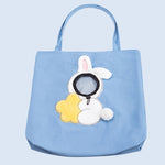 Blue tote bag with a bunny and flower design on a light blue background
