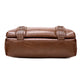 Brown leather clutch bag with decorative straps on a white background