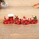 Red toy train with teddy bears and a tree on a wooden surface