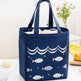 Navy blue tote bag with fish pattern on a white surface