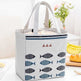 Tote bag with fish pattern on a table with bananas and flowers in the background