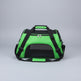 Green pet carrier with black straps on a carpeted floor