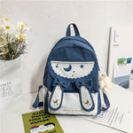 Blue and white backpack with decorative elements on a surface with a light background