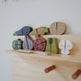 Set of wooden toy vegetables on a wooden stand against a white background