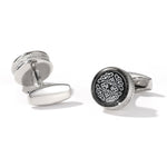 Silver cufflinks with intricate design on a white background