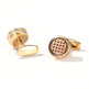 Gold cufflinks with intricate design on a white background