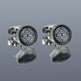 Pair of silver cufflinks with intricate black and white design on a gray background