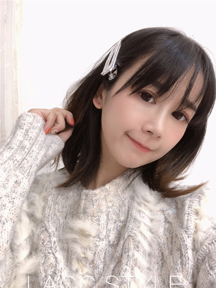 Woman with a hair clip in her hair, wearing a textured white sweater.