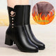 Black ankle boots with decorative elements on a light background, showing plush lining detail.