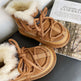 Pair of brown winter boots with fur lining on a surface.