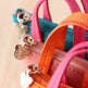Close-up of colorful handbags with decorative charms on a beige background