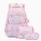 A pastel pink backpack set with matching pouches, featuring a watercolor polka dot pattern in shades of blue, orange, and yellow. The set includes a backpack, a small shoulder bag, and a pencil case, with a heart-shaped charm on the backpack that reads 'Barbie Girls'.