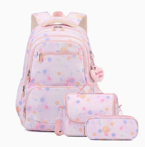 A pastel pink backpack set with matching pouches, featuring a watercolor polka dot pattern in shades of blue, orange, and yellow. The set includes a backpack, a small shoulder bag, and a pencil case, with a heart-shaped charm on the backpack that reads 'Barbie Girls'.