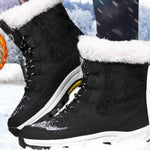 Black winter boots with white fur lining on a snowy background