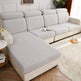 Gray and beige sectional sofa in a living room setting with a rug and side table.
