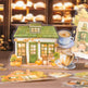 Decorative paper house with coffee-themed elements on a table.