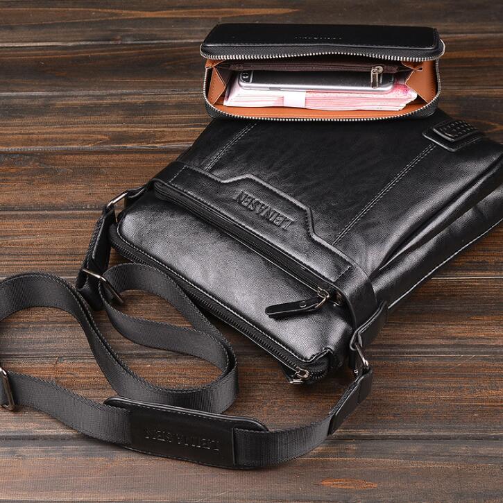 Black leather bag with a shoulder strap on a wooden surface