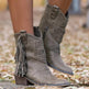 Gray fringe boots worn outdoors on a blurred natural background