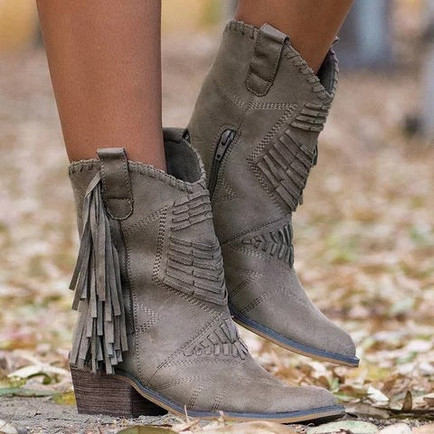 Gray fringe boots worn outdoors on a blurred natural background