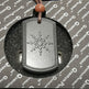 Dog tag pendant with braille text on a gray background