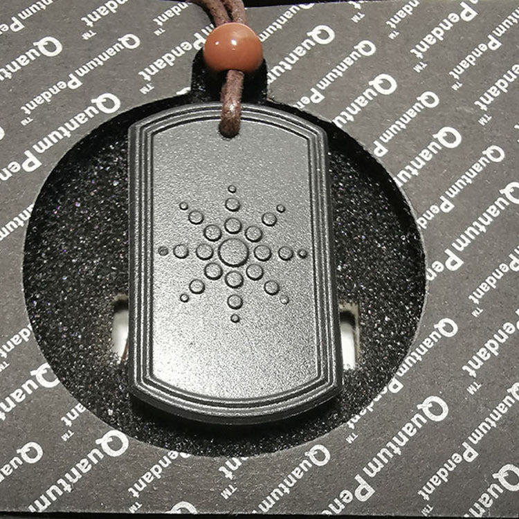 Dog tag pendant with braille text on a gray background