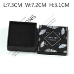 Black jewelry box with feather design and text on a white background