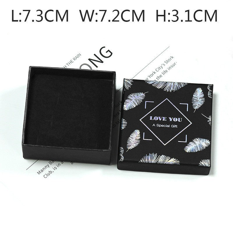 Black jewelry box with feather design and text on a white background