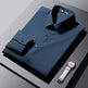 Folded navy blue dress shirt with a white wristwatch on a gray surface