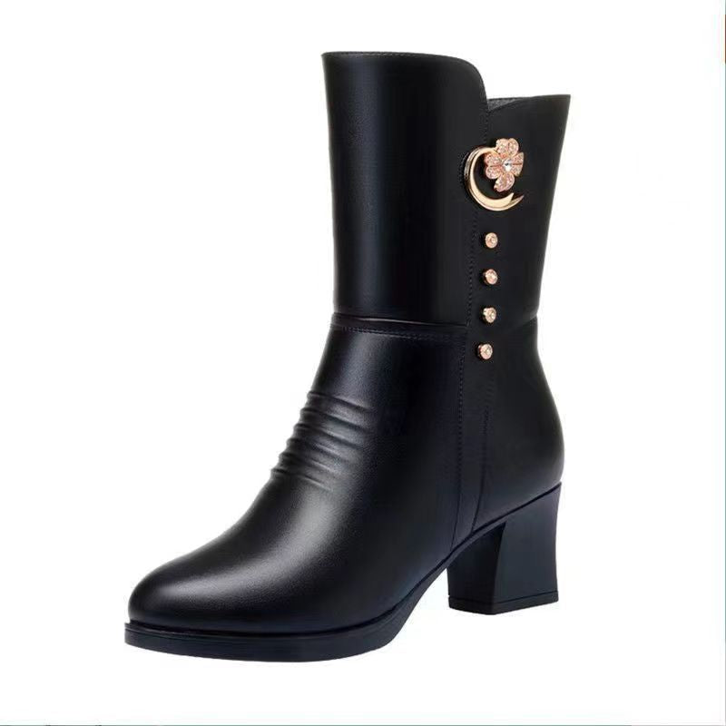 Black leather boot with decorative buttons on a white background