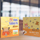 Two packaging boxes for a kids tablet PC on a wooden surface with a blurred indoor background.