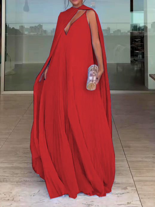 Red evening gown with a cape worn by a person indoors.