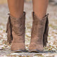Brown fringe boots on a blurred natural background