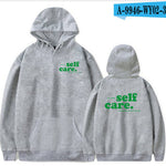 Gray hoodie with 'self care.' text on front and back, on a white background.