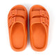 Pair of orange sandals with buckle straps on a white background