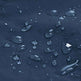 Close-up of clear water droplets resting on a dark navy blue textured surface.