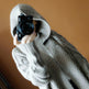 Person wearing a gray hoodie holding a camera against a brown background