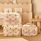A beige backpack and matching lunch bag set with red polka dots and pink embroidered 'Isabella' text, styled on a woven rug in front of a wooden Kids Corduroy Backpack & Lunch Bag Set – Handmade Chunky Yarn, 7 Colour Combos. 