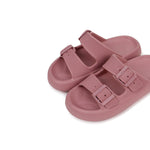 Pair of pink sandals with buckle straps on a white background