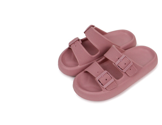Pair of pink sandals with buckle straps on a white background