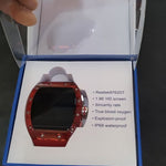 Red smartwatch in a box with specifications on a dark surface