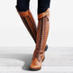Brown knee-high boots with detailed laces on a light background