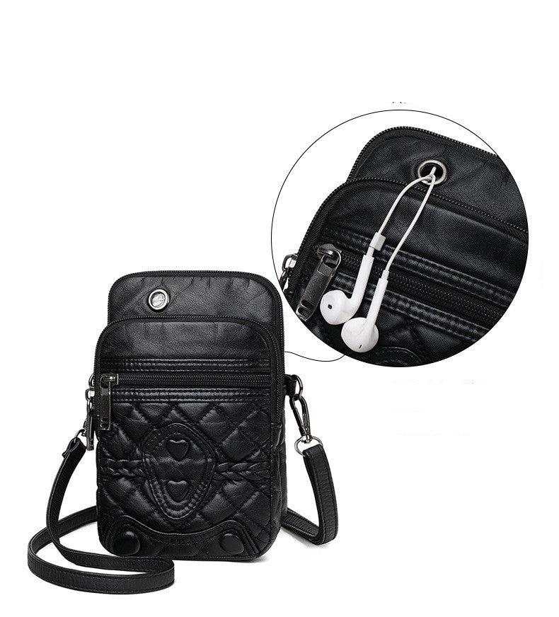 Black crossbody bag with quilted design and earphone pocket on a white background