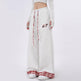 White sweatpants with red plaid accents and a small graphic on a white background