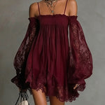 Woman wearing a burgundy off-shoulder dress with sheer sleeves against a gray background
