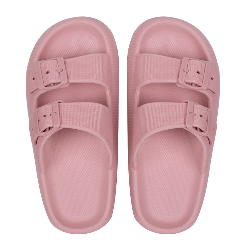 Pair of pink sandals with buckles on a white background