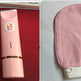 Pink electronic device and scrubber on a red and gray background