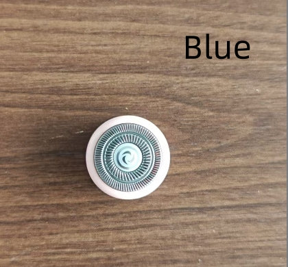 Round blue object with a white border on a wooden surface, labeled 'Blue'.